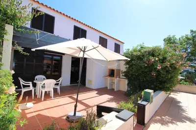 a patio with an umbrella and a table and chairs at Vilar do Jardim 59 - Clever Details in Vilamoura