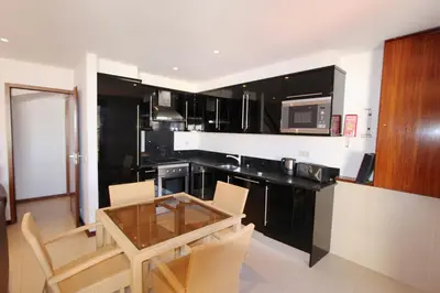 a kitchen with a glass table and a microwave at Vilar do Jardim 59 - Clever Details in Vilamoura