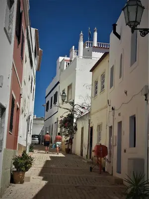 a group of people walking down a street with buildings at Casa do Sal in Albufeira