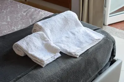 two white towels sitting on top of a bed at Peneco II in Albufeira