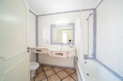 a bathroom with a sink and a toilet and a mirror at Apartamentos Solar do Sol in Albufeira