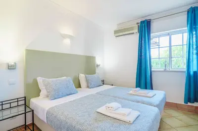 a bathroom with a sink and a toilet and a window at Apartamentos Solar do Sol in Albufeira