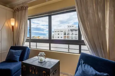 a room with two blue chairs and a large window at Blue Boat in Quarteira