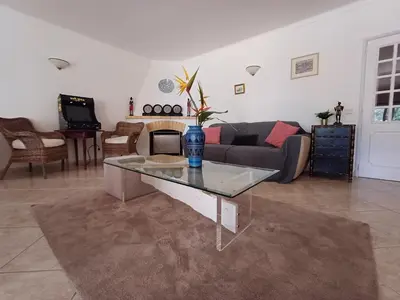 a living room with a couch and a glass table at The Pinewood Villa in Vilamoura