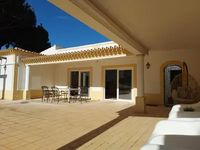a patio with chairs and a table in a house at The Pinewood Villa in Vilamoura