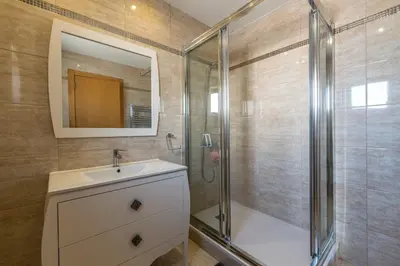 a bathroom with a shower and a sink and a mirror at Blue House Corcovada in Albufeira