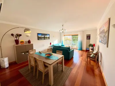 a living room with a table and a green couch at Blue House Corcovada in Albufeira