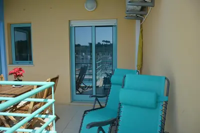 a room with a blue chair and a balcony at Beautiful Apartment In Albufeira Marina in Albufeira