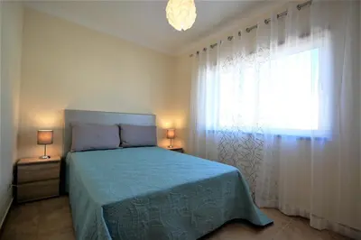 a bedroom with a bed and a large window at Apartamento Edificio Ibérico - Albufeira downtown in Albufeira