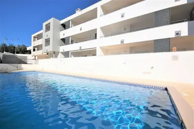 a swimming pool in front of a building at Apartamento Edificio Ibérico - Albufeira downtown in Albufeira