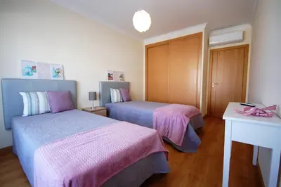 a bedroom with two beds with pink and blue sheets at Apartamento Edificio Ibérico - Albufeira downtown in Albufeira