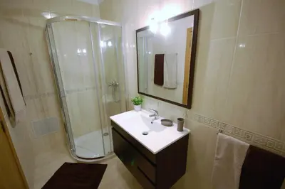 a bathroom with a sink and shower with a mirror at Apartamento Edificio Ibérico - Albufeira downtown in Albufeira