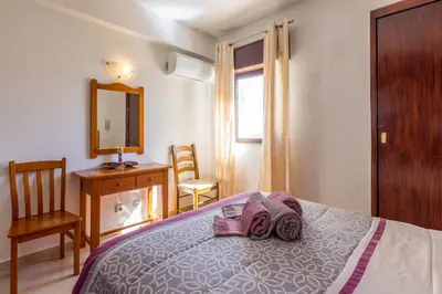 a bedroom with a bed and a desk and a mirror at Apartamento Correia in Albufeira