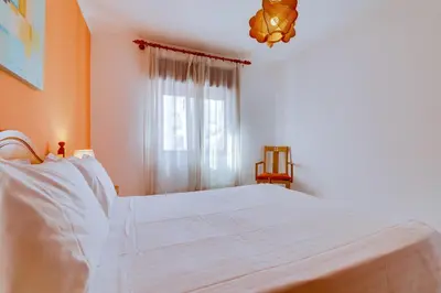 a living room with a table and chairs and a television at Apartamento T1 praia in Quarteira