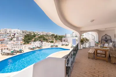 a table on a balcony with a view of the city at ETHOS Bertolina Wellness Urban Living in Albufeira