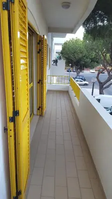 a yellow door on a balcony of a building at GelbBlau Falésia in Albufeira