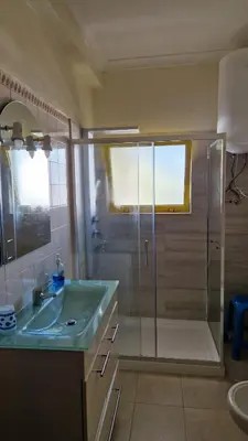 a bathroom with a glass shower and a sink at GelbBlau Falésia in Albufeira