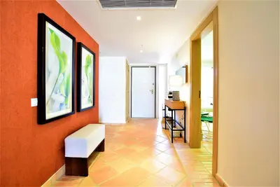 a hallway with orange walls and a white bench at T3 Vila Sol Village in Quarteira