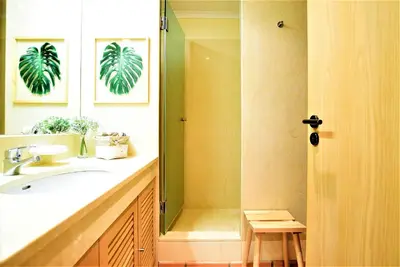 a bathroom with a sink and a shower with a mirror at T3 Vila Sol Village in Quarteira