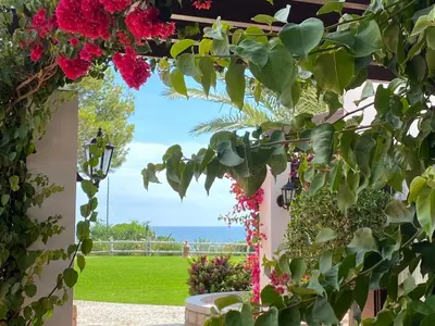 a patio with flowers and a view of the ocean at Algarve Luxury Experience - Situated within the Pinecliffs Resort in Albufeira