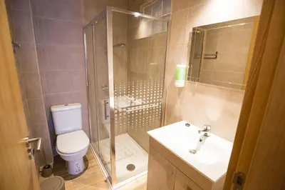 a bathroom with a shower and a toilet and a sink at 1977 in Faro