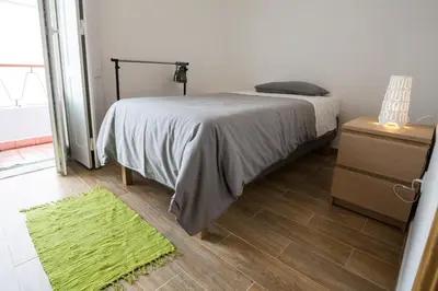a bedroom with a bed and a green rug at 1977 in Faro