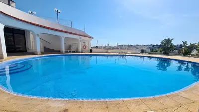 a large blue swimming pool in front of a building at Albufeira Ocean view (62) in Albufeira
