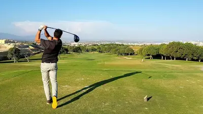 a man swinging a golf club on a golf course at Albufeira Sea view (51) in Albufeira