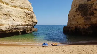 two boats sitting on a beach near the water at Albufeira, Cerro Branco (42) in Albufeira