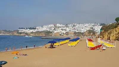 a beach with chairs and umbrellas and people on it at Albufeira, Cerro Branco (42) in Albufeira