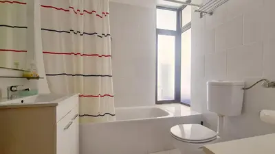 a bathroom with a tub and a toilet and a shower curtain at Albufeira, Sea and old town view (32) in Albufeira