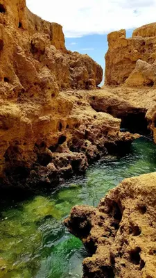 a body of water next to some rocks at Albufeira, Sea and old town view (32) in Albufeira