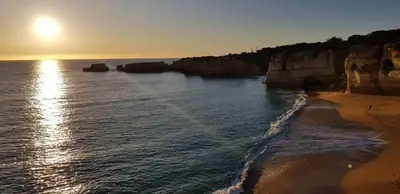a view of a beach with the sun rising over the water at Albufeira, Sea and old town view (32) in Albufeira