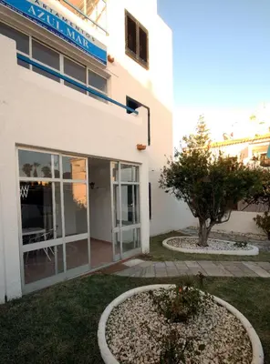 a building with a door and a tree in front of it at Apartamentos Azul Mar in Albufeira