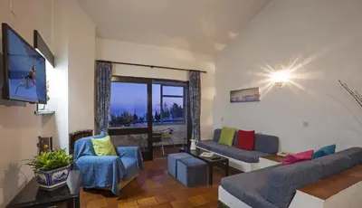 a living room with a couch and chairs and a tv at Apartamentos Azul Mar in Albufeira