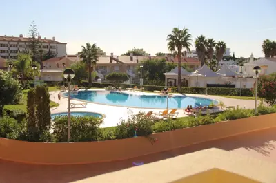 a table and chairs on a balcony with a view of a pool at Appartement Villamoura in Vilamoura