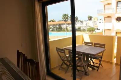 a swimming pool in a courtyard in front of some buildings at Appartement Villamoura in Vilamoura