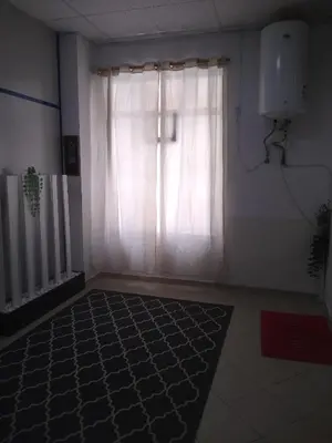 a room with a window with a white curtain and a rug at Melaya Budget Hostel in Faro