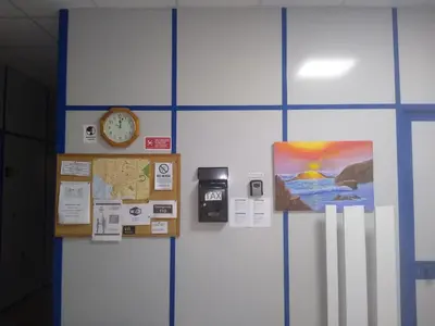 a wall with a clock and a picture on it at Melaya Budget Hostel in Faro