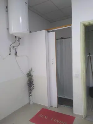 an empty room with a shower and a red rug at Melaya Budget Hostel in Faro