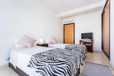 a hotel room with two beds and a television at Ouranascente in Albufeira