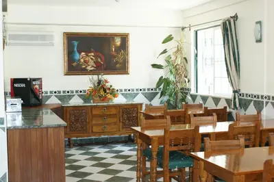 a dining room with tables and chairs and a painting on the wall at VilaBranca in Albufeira