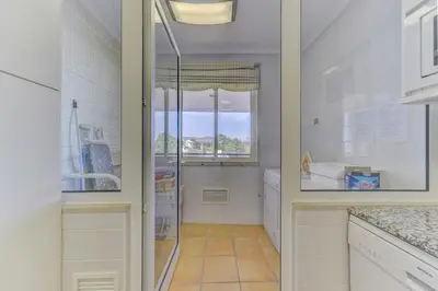 a kitchen with a walk in shower and a window at Apartamento Vila Sol com terraço e jacuzzi privad in Quarteira