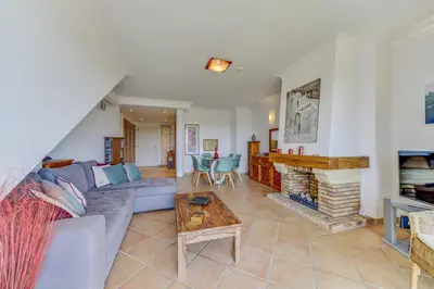 a living room with a couch and a fireplace at Apartamento Vila Sol com terraço e jacuzzi privad in Quarteira