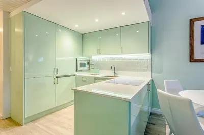 a kitchen with white cabinets and a sink at THE LAKERS Boutique Apartment in Quinta do Lago