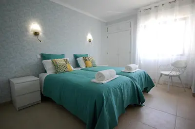 a bedroom with a green bed with two towels on it at Apartamento Velamar - 250 m from the Beach by Bedzy in Albufeira