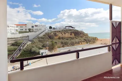 a view of the beach from the balcony of a building at Edificio Albufeira Apartamentos A. Local - Albuturismo Lda in Albufeira