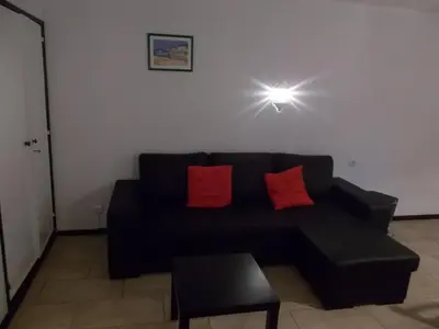 a black couch with two red pillows in a living room at Bellavista Studio in Albufeira