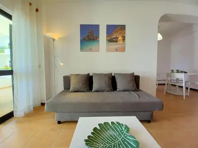 a living room with a couch and a table at Sol Nascente- Piscina, Wifi, Familiar in Vilamoura