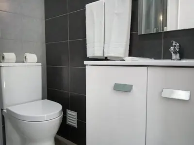 a bathroom with a white toilet and a sink at Mamamia AC&Vista Magnifica in Quarteira